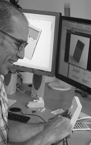 Picture of industrial designer measuring a plastic moulded part for an electronic keypad